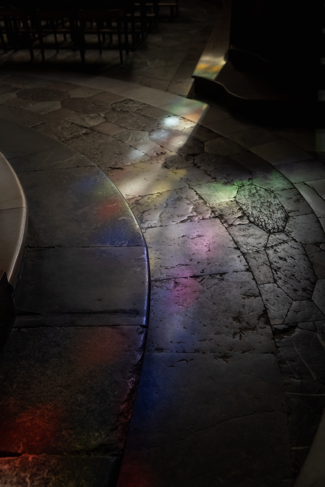 Ambiance magique à la cathédrale de Tarbes : reflet coloré des vitraux sur le sol lors d'une cérémonie de mariage.